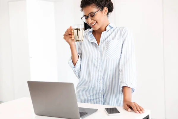 Jovem mulher africana atraente trabalhando no computador portátil — Fotografia de Stock