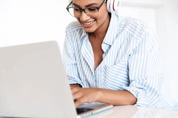 Jovem mulher africana atraente trabalhando no computador portátil — Fotografia de Stock