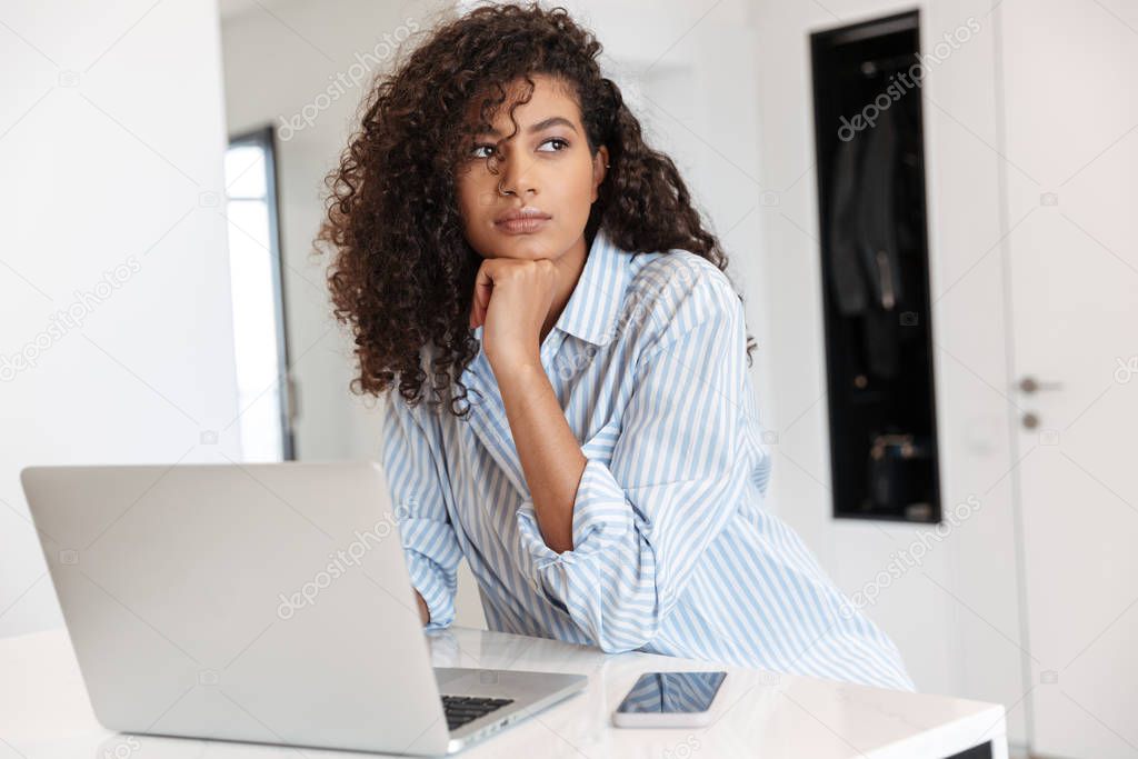 Attractive young african woman working on laptop computer