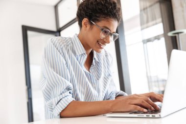 Attractive young african woman working on laptop computer