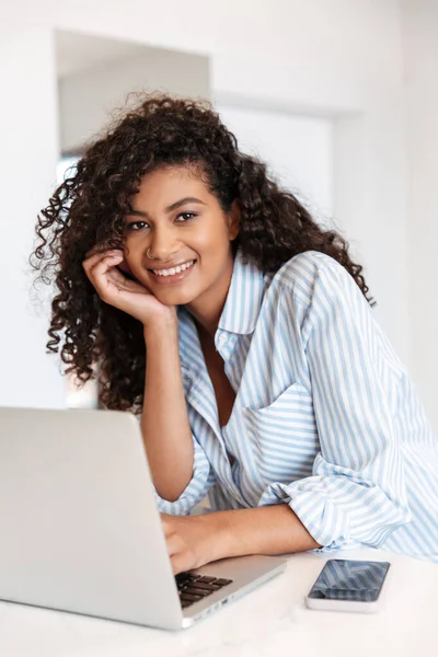 Jovem mulher africana atraente trabalhando no computador portátil — Fotografia de Stock