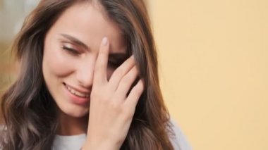 Güzel bir kadın binanın yanında dururken gülümsüyor.