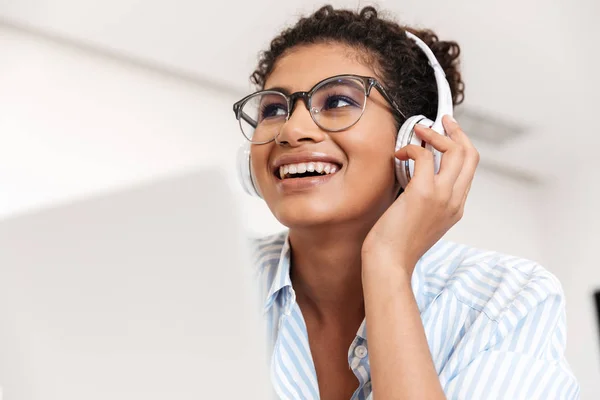 Attraktive junge Afrikanerin arbeitet am Laptop — Stockfoto