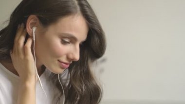 Hoş, sakin bir kadın içeride telli kulaklıkla müzik dinliyor.