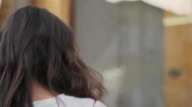 Dışarıda, binanın yanında yürürken çekici bir kadın görüntüsü dönüyor.