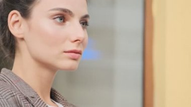 Sakin ve şık bir iş kadını ellerini çapraz yapıp dışarıda bekliyor.