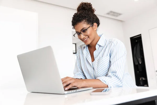 Jovem mulher africana atraente trabalhando no computador portátil — Fotografia de Stock