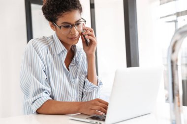 Attractive young african woman working on laptop computer