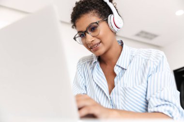 Attractive young african woman working on laptop computer