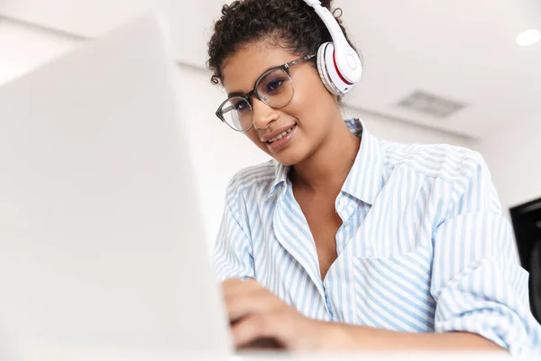 Attraktive junge Afrikanerin arbeitet am Laptop — Stockfoto