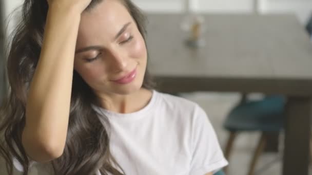 Uma Bela Jovem Está Sentada Mesa Tocando Seu Cabelo Dentro — Vídeo de Stock