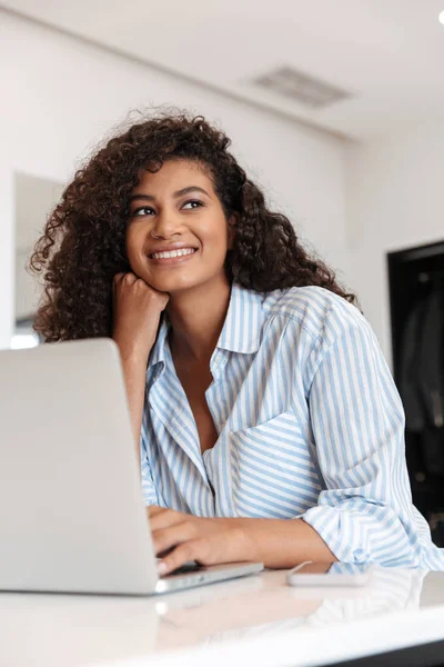 Attractive young african woman working on laptop computer — Stock Photo, Image