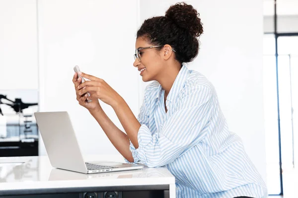 Attraktive junge Afrikanerin arbeitet am Laptop — Stockfoto