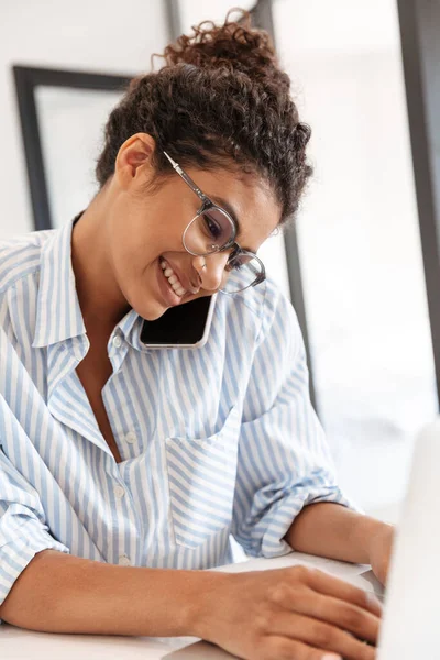 Attractive young african woman working on laptop computer — Stock Photo, Image