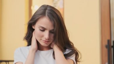 Çekici bir kadın binanın yanında yürürken saçlarını sallıyor.