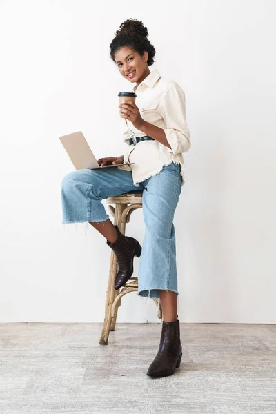 Smiling lovely stylish african woman holding laptop computer — Stok fotoğraf