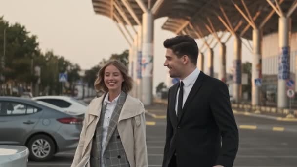 Güler Yüzlü Çifti Birlikte Yürüyor Havaalanının Yakınındaki Otoparkta Eğleniyor — Stok video