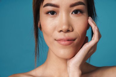 Pozitif gülümseyen Asyalı kadın çıplak poz veriyor.