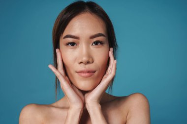 Pozitif gülümseyen Asyalı kadın çıplak poz veriyor.