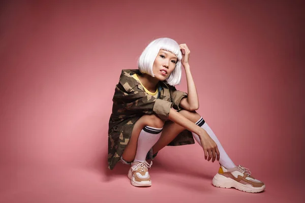 Imagem de jovem asiático menina vestindo branco peruca sentado e olhando — Fotografia de Stock