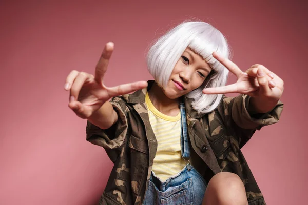 Imagem de menina asiática vestindo peruca branca sorrindo e gesticulando peac — Fotografia de Stock