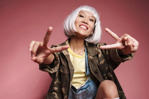 Image de fille asiatique portant une perruque blanche souriante et gestuelle peac — Photo