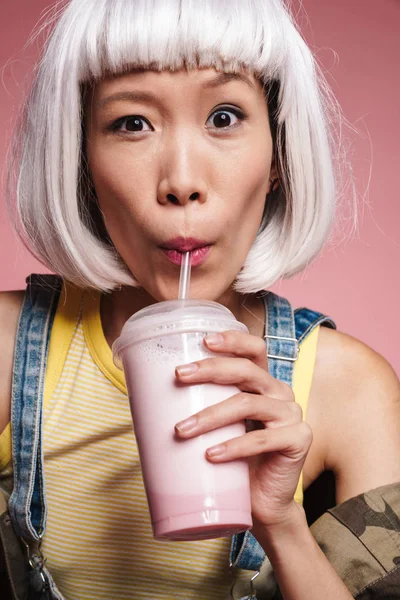 Imagem de menina asiática vestindo peruca branca bebendo milkshake de pl — Fotografia de Stock