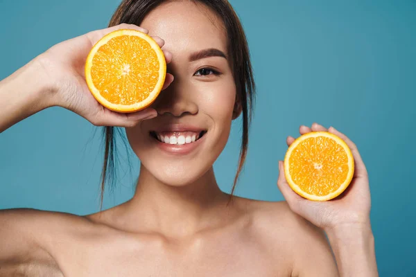 Retrato de mujer asiática semidesnuda sosteniendo naranja y sonriendo — Foto de Stock