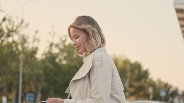 Вид Сбоку Улыбающуюся Блондинку Пальто Открытый Багажник Автомобиля Пультом Дистанционного — стоковое видео