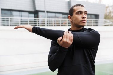 Yakışıklı genç sporcu egzersiz yapıyor.