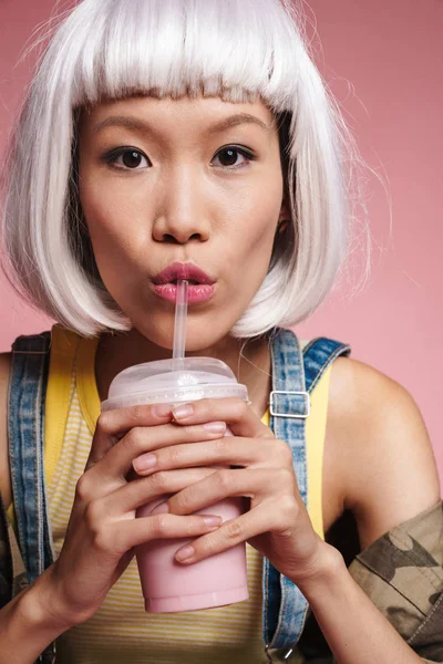 Afbeelding van aziatisch meisje dragen witte pruik drinken milkshake van pl — Stockfoto