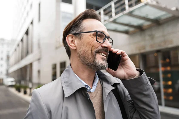 Imagen de hombre de negocios feliz hablando por celular y sonriendo —  Fotos de Stock