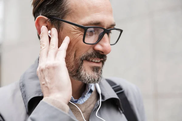Imagen de primer plano del hombre de negocios satisfecho usando auriculares — Foto de Stock