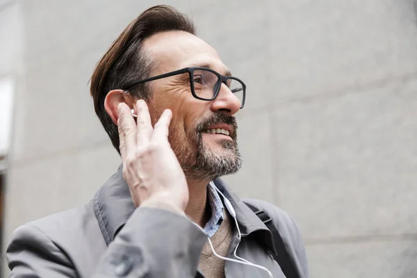 Imagen de primer plano del hombre de negocios sonriente usando auriculares — Foto de Stock