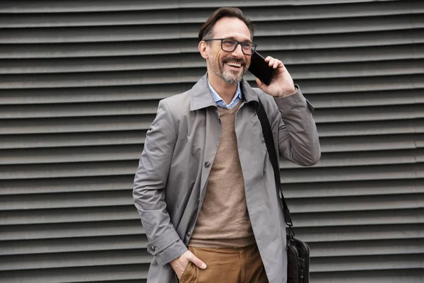 Bild av stilig skrattande affärsman talar på mobiltelefon — Stockfoto