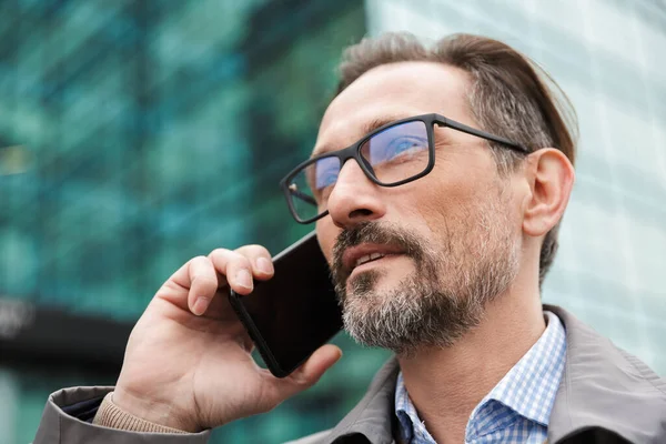 Imagen de un hombre de negocios guapo y serio hablando por celular — Foto de Stock