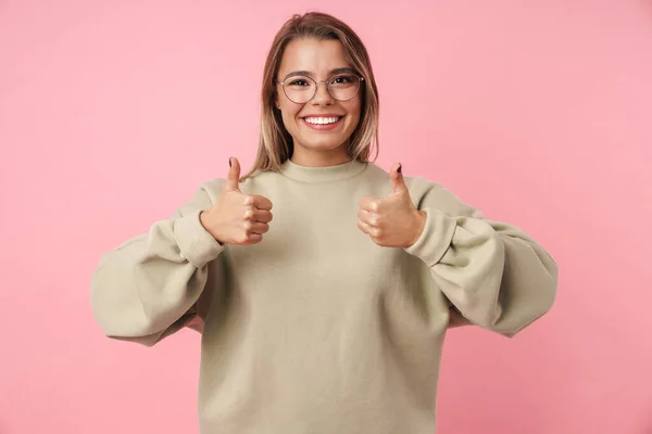 Retrato de jovem mulher satisfeita mostrando os polegares para cima e sorrindo — Fotografia de Stock