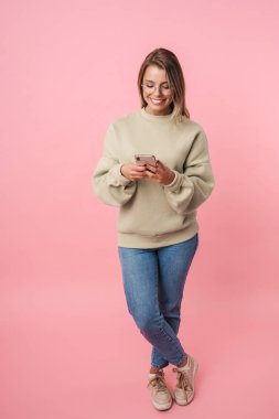 Gözlüklü, cep telefonu kullanan ve gülümseyen komik bir kadının portresi.