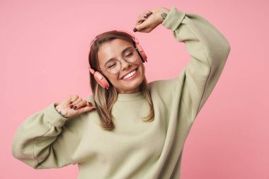 Sarışın mutlu kadının portresi. Kulaklık takıp dans ediyor.