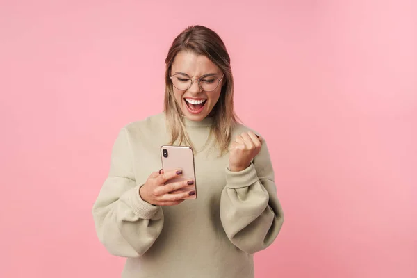 Портрет збудженої жінки з використанням мобільного телефону і жестом переможця — стокове фото