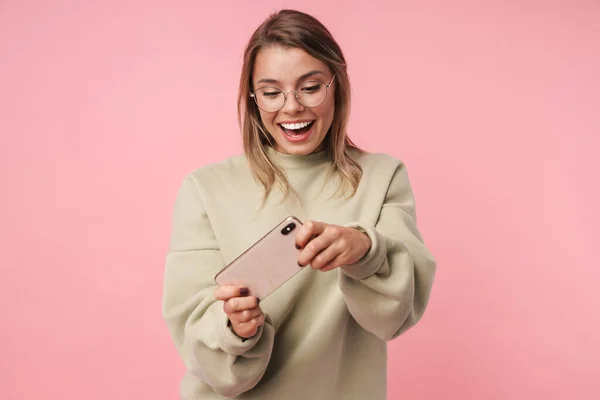 Retrato de una linda mujer sonriente jugando videojuego en el teléfono celular — Foto de Stock