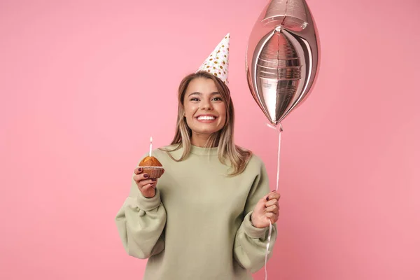 Портрет щасливої жінки, що тримає торт і повітряну кулю, посміхаючись — стокове фото