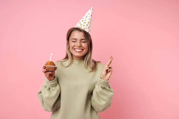 Портрет щасливої блондинки, що тримає торт і тримає пальці схрещеними — стокове фото