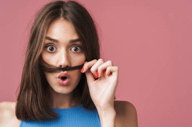 Image of young brunette woman having fun and putting her hair as