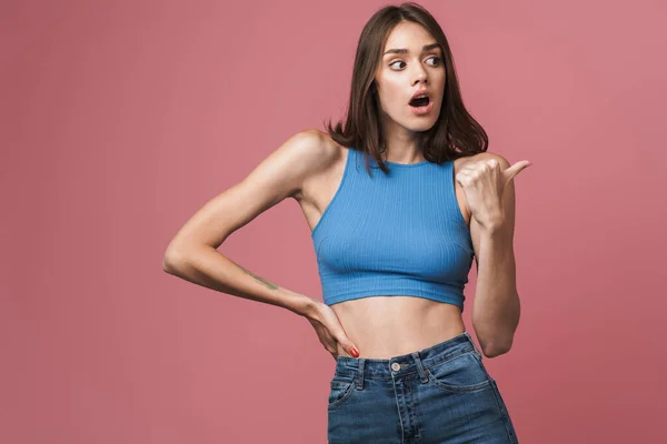 Image of young brunette woman wondering and pointing finger asid — Stok fotoğraf