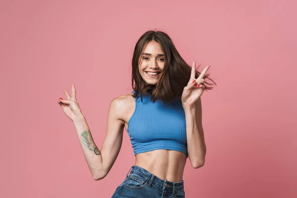 Imagem da jovem morena sorrindo e mostrando os dedos da paz — Fotografia de Stock