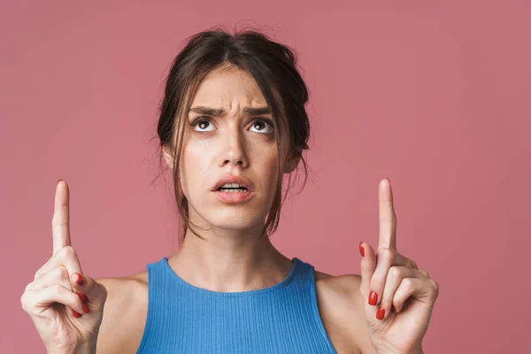 Image of young brunette woman pointing fingers upwards at copysp — Stok fotoğraf