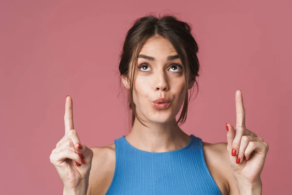 Image of young brunette woman smiling and pointing fingers upwar — Stockfoto