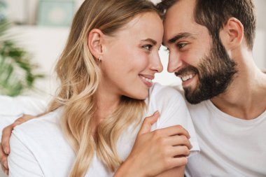 Loving couple indoors at home hugging.
