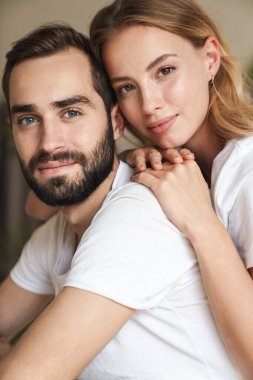 Optimistic loving couple indoors at home.